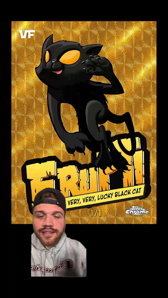 There are two men in the image - one standing near a poster with the phrase "FRUIT! Very Lucky Black Cat Erupt from Topps Chrome VEEFriends" written on it, and another man in front of him wearing a black baseball cap that has a picture of a cartoon cat on it. The people appear to be part of the post where someone placed a $100,000 bounty on an Eruption created by a character named Black Cat from a popular game series called VeeFriends.