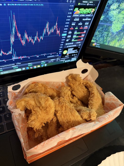 A box of Popeyes chicken tenders sits on a laptop keyboard in front of a trading screen showing the $TENDIES chart (currently at $14.286, up 72.1%), visually capturing the goal of Day 31 in the campaign to flip the price of a chicken tender.