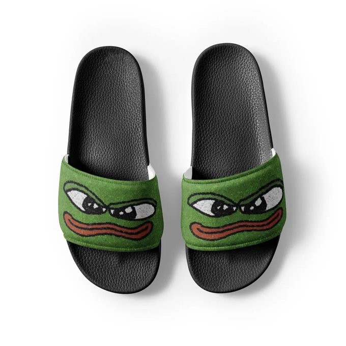 The image features a pair of green slippers with cartoon frog faces, which are designed for comfort and style. They appear to be made from a soft material like cotton or linen, making them suitable for summer wear. The slippers have black soles that provide support and durability while maintaining the overall aesthetic appeal. The frog face design adds a playful touch to the footwear, making it an interesting choice for those who enjoy unique and quirky styles.