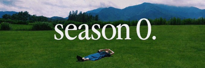 A person lies on a green grassy field with mountains in the background, overlaid with the text 'season 0.'