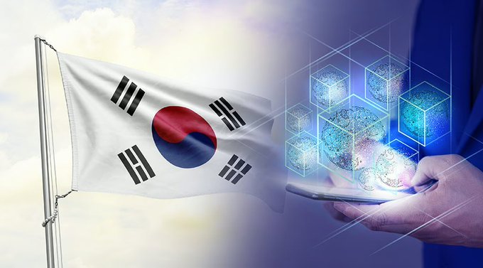 The South Korean flag waves against a cloudy sky, alongside a person holding a tablet displaying holographic molecular or data structures in blue light.