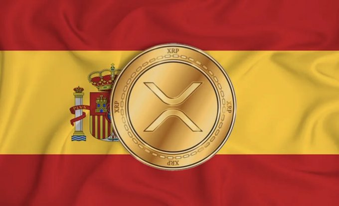 A gold XRP cryptocurrency coin displayed over the waving Spanish flag.