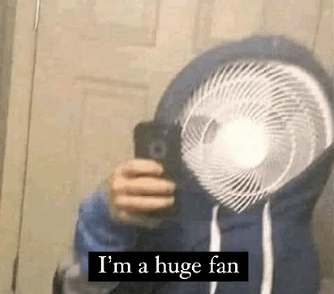 Blurry photo of a person taking a mirror selfie while wearing a hoodie that completely obscures their face with a hyper-realistic printed image of a box fan, captioned 'I'm a huge fan'.
