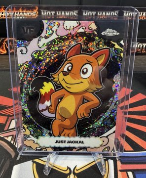 A holographic trading card featuring a cartoon jackal character with the text 'JUST JACKAL' at the bottom, displayed in a plastic stand.
