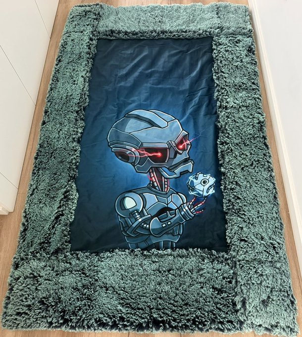 A shaggy teal area rug features a central panel depicting a blue-armored robot character with red glowing eyes.