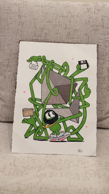 A small canvas painting on a beige couch depicts a cartoon character tangled in green vines around a large gray envelope, with a JPEG file icon and a floppy disk visible. The text 'BE A GOOD BRIEF' is signed at the bottom right.