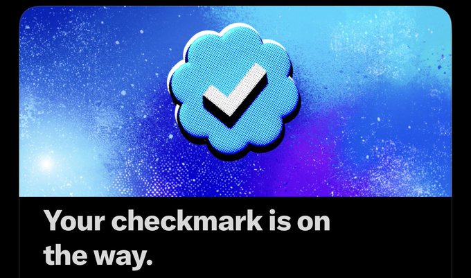 A graphic featuring a cloud-shaped speech bubble with a checkmark inside, set against a blue speckled background, with the text 'Your checkmark is on the way.' below.