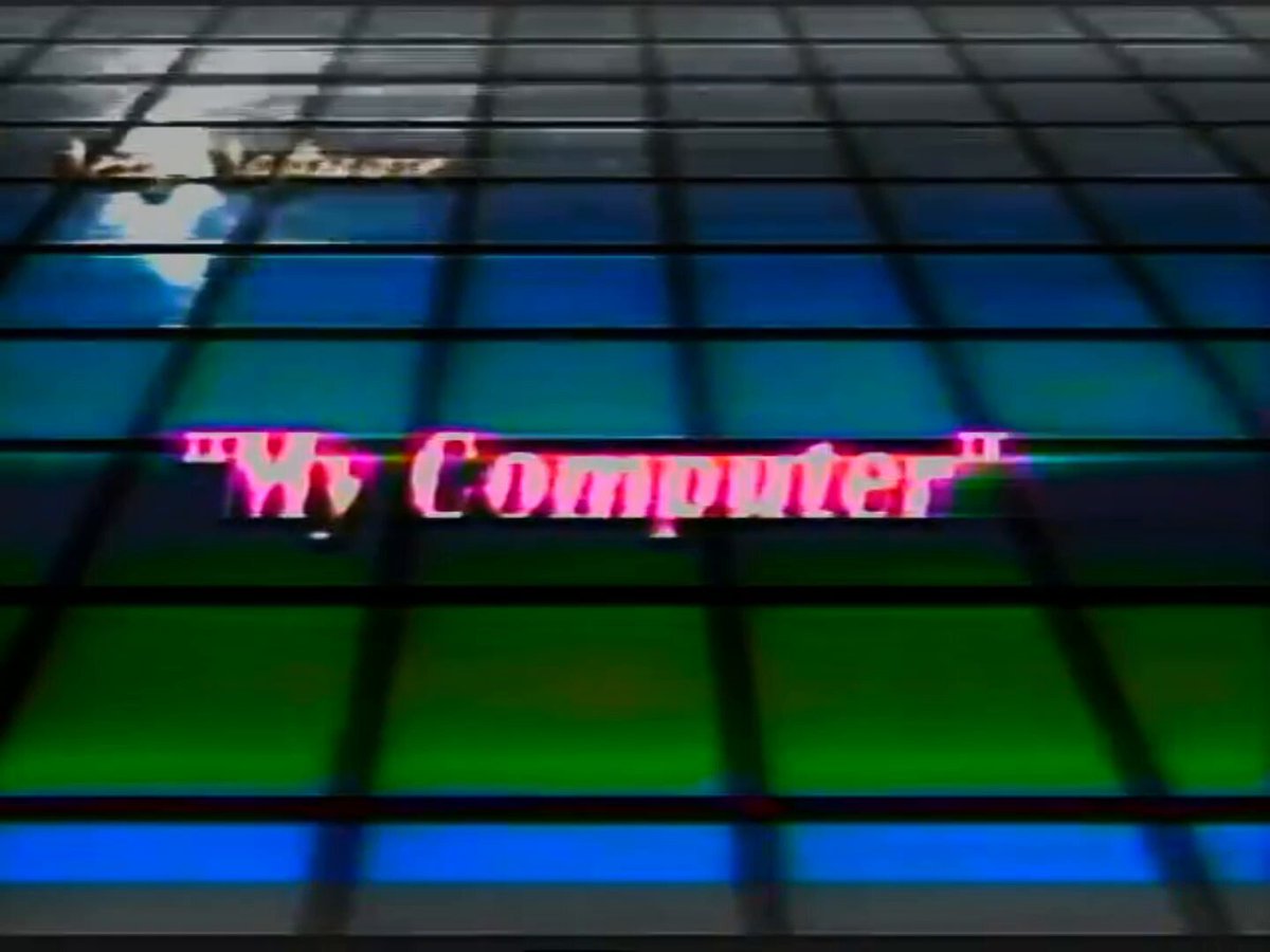 The image features a neon sign that reads "my computer" written in pink letters, which appears to be glowing or emitting light from within an electronic device. The background of the image consists of a grid-like pattern with blue and green colors. The image also contains text elements such as "by my computer", "V/H/Shorties", "exactly 1 of 3" and "March".