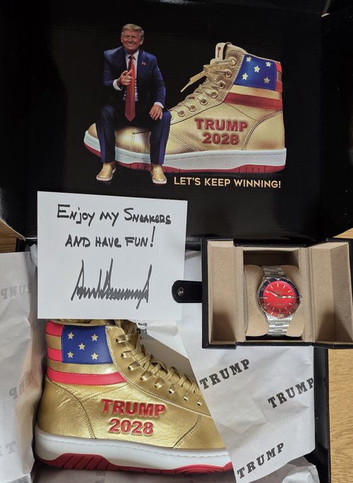 A box displays gold 'TRUMP 2028' sneakers, a Donald Trump-signed note reading 'ENJOY MY SNEAKERS AND HAVE FUN!', a Trump figurine, and a red-faced watch.