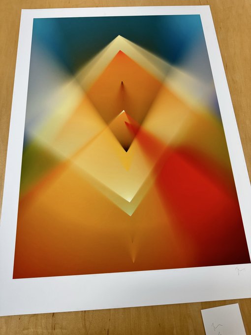 An abstract geometric art print featuring overlapping translucent diamond and square shapes in warm orange, yellow, and red tones, with a signature visible in the bottom right corner.