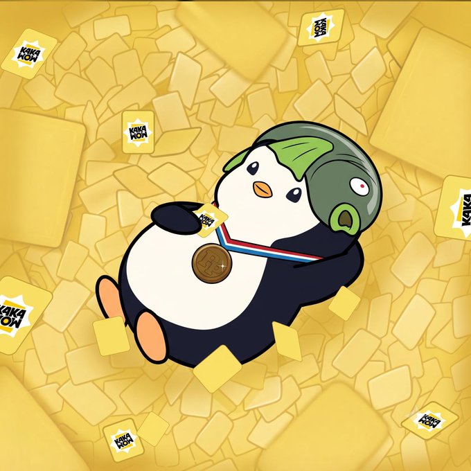 Cartoon penguin wearing a green aviator helmet with a medal around its neck, floating among yellow blocks labeled 'KAKAO NOW'.