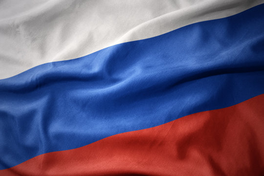 The Russian flag waves prominently, symbolizing Moscow's decisive move to launch nationwide crypto regulation on September 1, contrasted with the post's claim that U.S. Senate Majority Leader John Thune has stalled progress on the CLARITY Act by preventing a Senate vote.