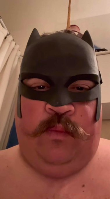 A man wearing a Batman mask and sporting a mustache poses for a close-up selfie, humorously aligning with the "gm degens" crypto greeting by adopting a playful, masked superhero persona for the new trading week.