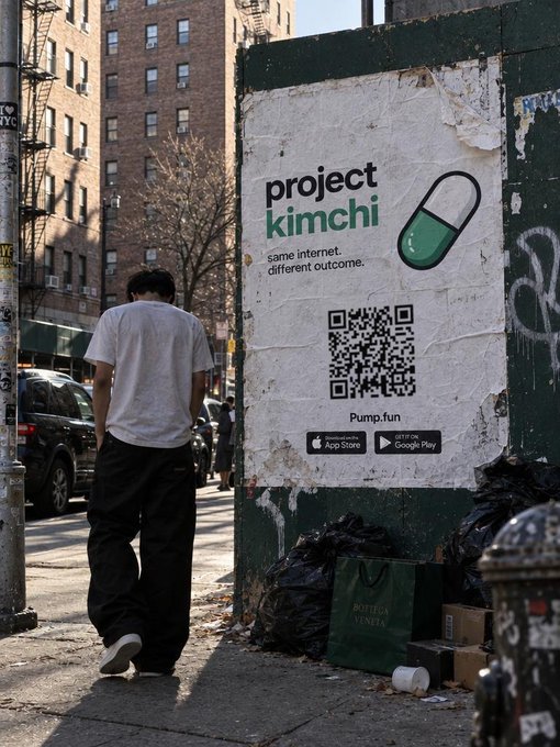 A street scene shows a person standing near a weathered wall advertisement for “project kimchi,” featuring a pill graphic, QR code, “Pump.fun,” and App Store and Google Play badges.