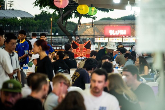A crowd gathers for a MetaMask Community Builder Night in India, as indicated by the recognizable MetaMask fox logo at the event. The image visually represents the community event that the accompanying post is announcing.