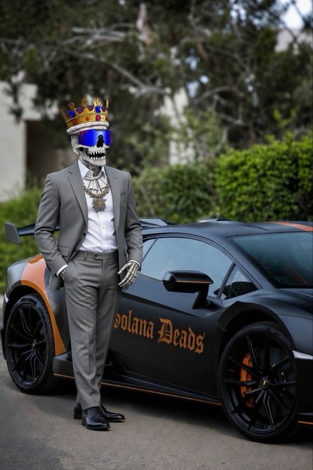 A person in a gray suit wearing a skull mask, blue sunglasses, and a gold crown, leaning against a black sports car with orange accents that reads 'Solana Deads' in orange lettering.