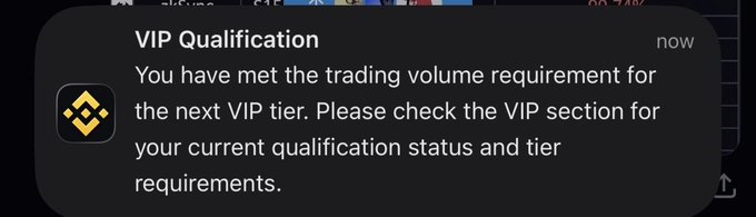 A Binance mobile notification titled 'VIP Qualification' stating the user has met the trading volume requirement for the next VIP tier.