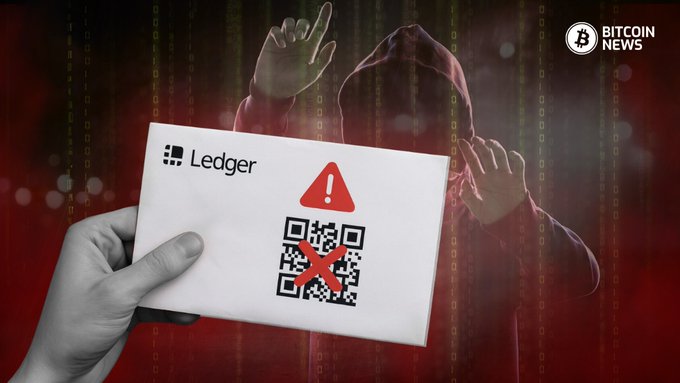 A news graphic with a red, digital matrix background shows a person in a red hoodie holding their hands up in a surrender pose. In the foreground, a hand holds a card with the Ledger logo, a red warning triangle, a QR code marked with a red 'X', while a 'Bitcoin News' logo sits in the top right corner.