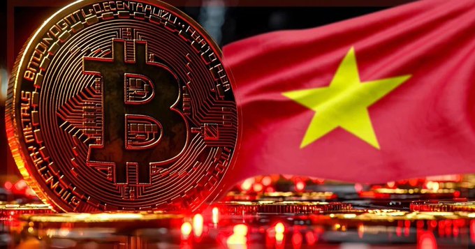 A close-up of a golden Bitcoin coin standing upright, with the red and yellow star flag of Vietnam waving in the background.