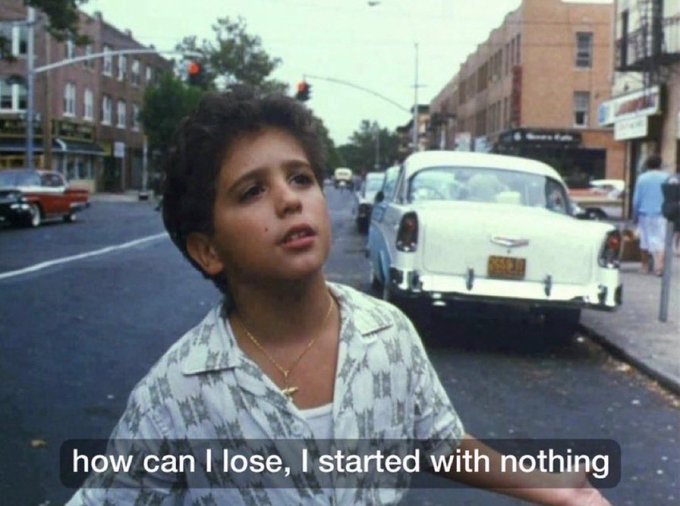 A young boy with curly hair and a gold cross necklace stands on a city street with classic 1950s cars behind him, beneath the caption "how can I lose, I started with nothing." The quote captures a fearless, risk-embracing mentality—reflecting how the poster approaches trading with the same beginner mindset of having nothing to lose, even after gaining experience.