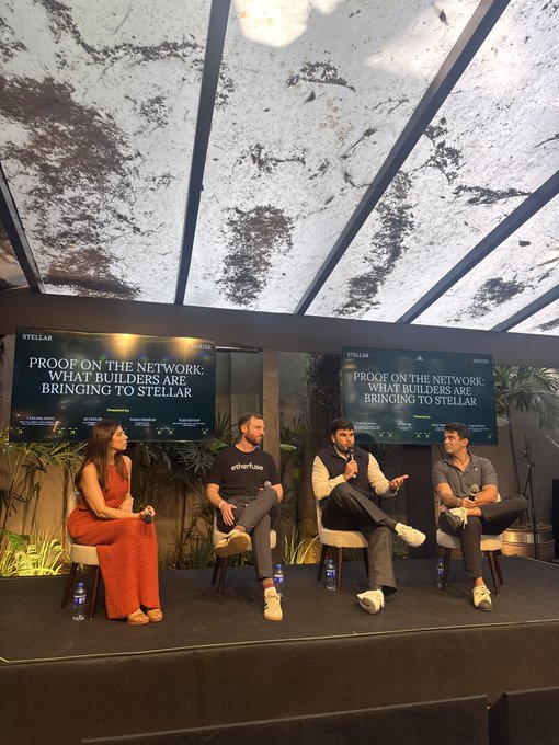 A panel discussion titled 'Proof on the Network: What Builders Are Bringing to Stellar' with four panelists seated on stage under a textured canopy.