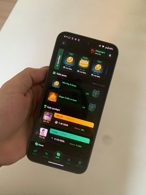 A hand holding a smartphone displaying a 'Hamster Kombat' or similar tap-to-earn game interface with 'Coin' balances, daily quests, and progress bars in SOL.
