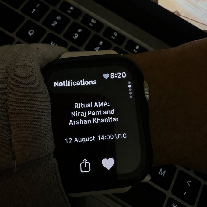 A smartwatch displays a notification reminder for the Ritual AMA with Niraj Pant and Arshan Khanifar scheduled for 12 August 14:00 UTC, corroborating the post's announcement of the community AMA with the Ritual Labs co-founder and founding engineer.