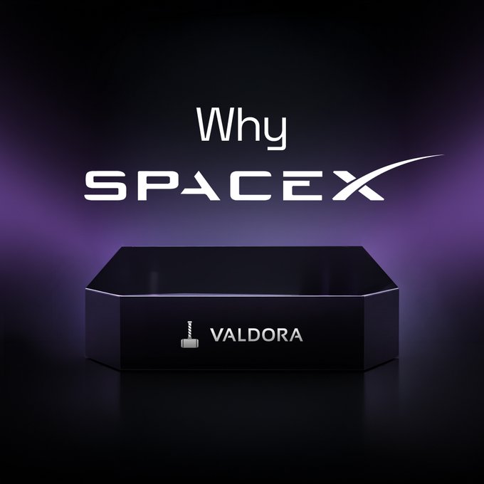 The image features a black box with the words "Valdora" written on it. The box appears to be made of metal or plastic and has a white logo on its side, which reads "SPCX". The background of the image is dark purple, creating a striking contrast with the black box. The text in the image reads "Why SPCX", indicating that there might be some information about the company's IPO or other related topics.
