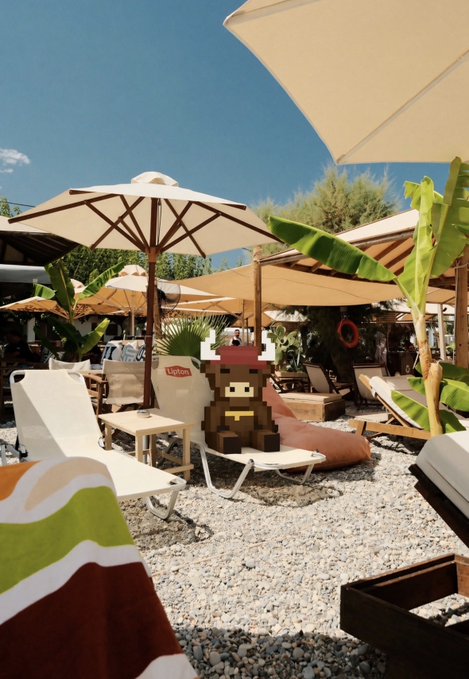 A sunny beach club scene with umbrellas, lounge chairs, and tropical plants, featuring a pixel-art monkey mascot with a 'Lygos' name tag.