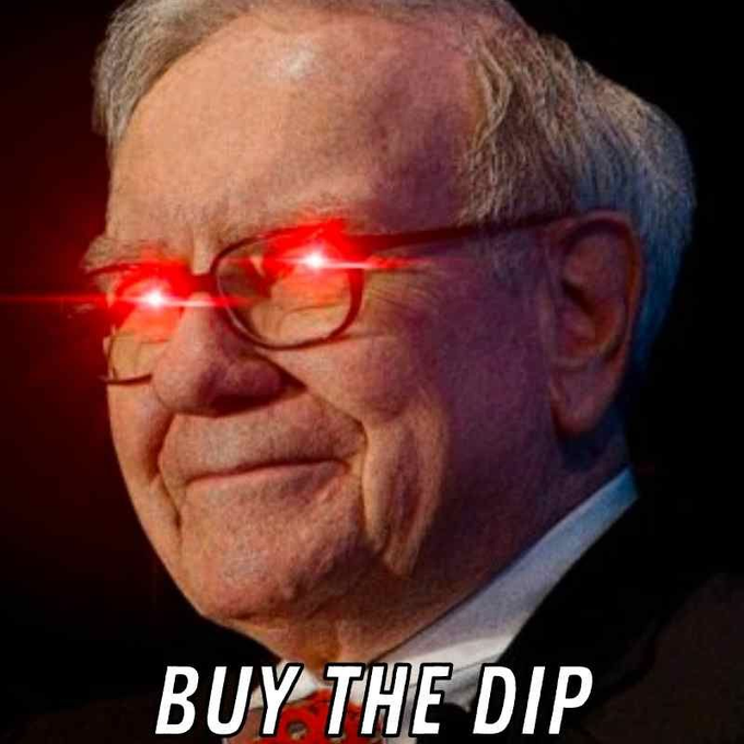 Warren Buffett's face is edited with glowing red laser eyes, paired with the caption "BUY THE DIP" in bold white text at the bottom. The image humorously embodies a defiant investor mentality, fitting the post's listing of multiple cryptocurrencies experiencing significant price drops during a market-wide selloff.