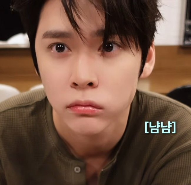 A close-up of a young man with dark hair looking emotional with slightly teary eyes, wearing an olive green shirt, with the Korean text '[남바] ' visible in the corner.