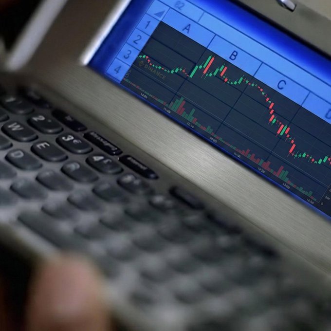 A close-up view of a BlackBerry device displays a stock chart on its screen with candlestick patterns in red and green, alongside letters A, B, C, and D marking different sections. The image relates to the caption "what a Dilemma" by capturing the tense moment of analyzing market fluctuations, reflecting the uncertainty and decision-making involved in trading or investing.