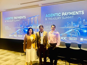 Three attendees pose in front of the illuminated stage backdrop at the "Agentic Payments & Treasury Summit 2026" in Singapore, with sponsor logos including XDC and SWITCH visible below the event's title.