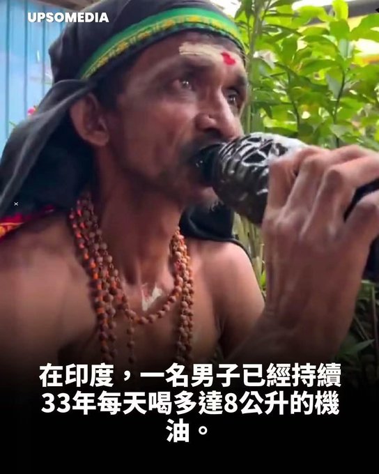A close-up of a man with a forehead marking, wearing beaded necklaces and a green head covering, drinking from a dark bottle; overlaid Chinese text mentions a man in India drinking 8 liters of machine oil daily for 33 years, branded with 'UPSOMEDIA'.