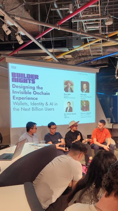 A panel discussion titled 'BUILDER NIGHTS: Designing the Invisible Onchain Experience - Wallets, Identity & AI in the Next Billion Users' featuring speakers Taran Sabharwal, Ridhays, Praveen, and Bo, with audience members visible in the foreground.