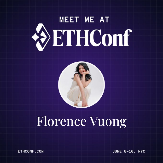 The image features a woman sitting down with her legs crossed, wearing white pants. The background of the image is blue, and there are logos for EthCon and ETHCON visible. The text "Meet Me At" is written above the woman's head, indicating that she is being introduced to someone at an event called EthCon.