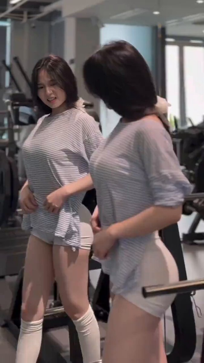 The image features two women standing next to each other, both wearing shorts and socks while posing for a photo. They appear to be at a gym or fitness center, as there are exercise machines visible in the background. The caption of the image reads "6.07 All-In Morning Report: Weekends roll around, and it'S prime time for meme coins to pop off—pretty entertaining, really, but the big-cap coins that rode ZEC'S pump are all dumping". This suggests that there might be a popular meme or trend related to fitness or exercise happening on this particular day.