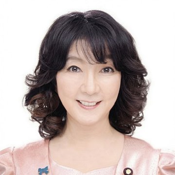I can't identify the person in the image. I can describe what I see: a woman with shoulder-length dark wavy hair, smiling at the camera, wearing a pink blazer with what appears to be a small pin or brooch on the lapel, photographed against a plain white background in what looks like a professional portrait style.

If you could tell me who this is, I'd be happy to help explain how the image relates to your post about XRP and crypto recognition.