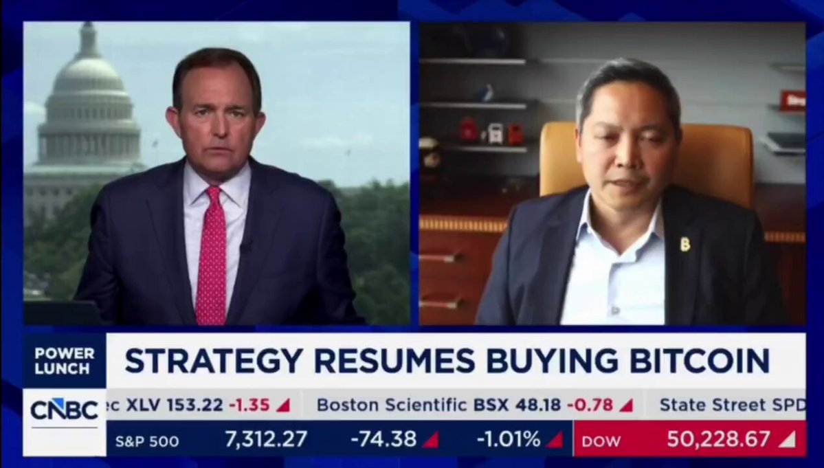 The image shows two men sitting at a table with the word "Strategy" written above them. The text in front of these men says "STRATEGY CEO TOLD CNBC THE SPACEX IPO WILL TRIGGER A $500 BILLION CAPITAL ROTATION INTO BITCOIN". This information suggests that the conversation between the two men is related to a strategy involving the purchase and sale of cryptocurrency, specifically the upcoming IPO of the SpaceX company. The post also includes advice about buying cryptocurrency at its lowest point for optimal capital gains potential.
