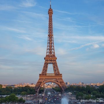 The Eiffel Tower in Paris photographed at dusk with blue sky and cityscape below, watermarked '@watcher.news'.