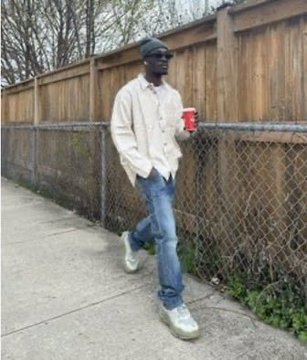 A man walks down a sidewalk holding a red cup, dressed in a cap, cream jacket, and jeans. The image humorously captures the overconfident swagger of someone who thinks they've won a crypto giveaway—right before getting scammed for their seed phrase.