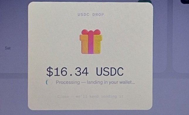 A digital pop-up shows a 'USDC DROP' of $16.34 USDC with a gift box icon and text 'Processing — landing in your wallet...'