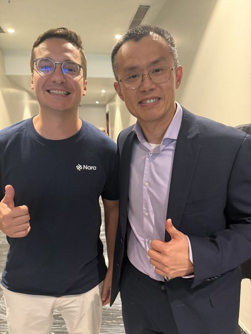 Two men pose together with thumbs up, one wearing a navy "Nara" t-shirt and the other in a suit, alongside a caption celebrating a meeting with @CZ_Binance to discuss how stablecoins like @nara_usd can fund the real economy.