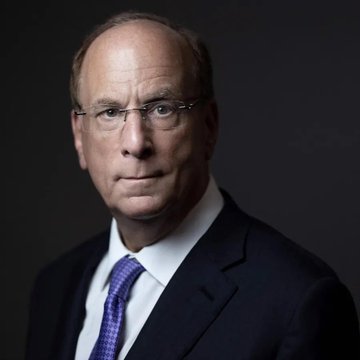 A professional portrait of a middle-aged man wearing glasses, a dark suit, white shirt, and purple patterned tie against a black background. The image likely depicts a senior BlackRock executive, visually representing the company's support for the CLARITY Act alongside Ripple ($XRP).