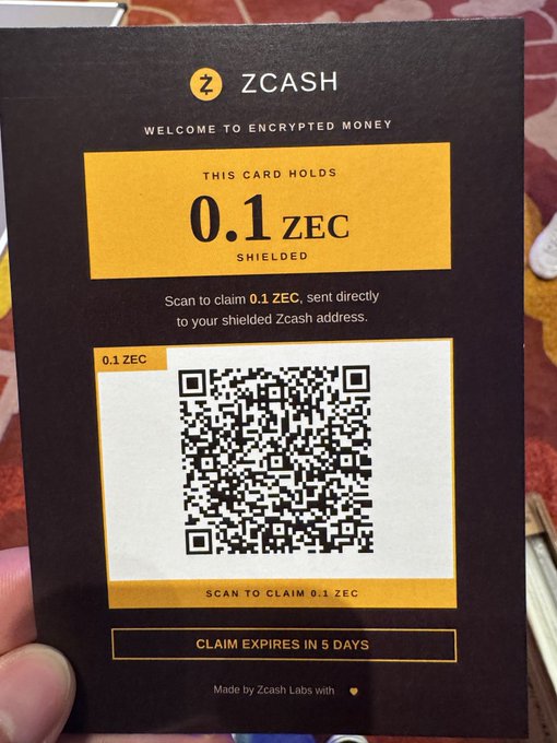 A black ZCASH card that says "WELCOME TO ENCRYPTED MONEY" and "THIS CARD HOLDS 0.1 ZEC SHIELDED," featuring a QR code to claim 0.1 ZEC with a note that the claim expires in 5 days.