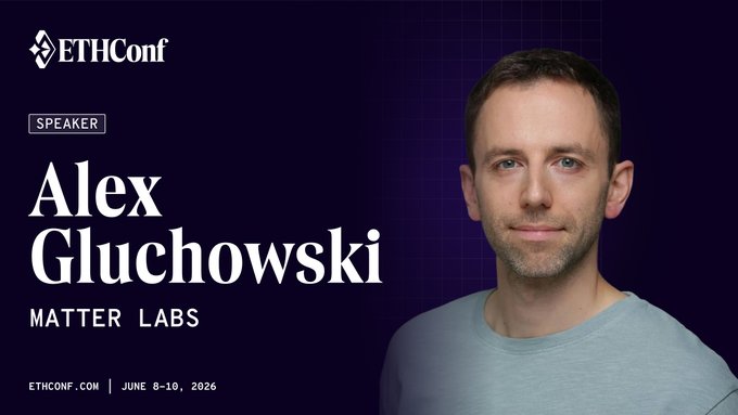 The image features a man wearing a gray t-shirt, standing against a purple background with white text that reads "ETHCONF" at the top of the image. Below him, there are two lines of text written in black font, one reading "Speaker Alex Glucowski Matter Labs" and another stating "June 8th - 10th in Wall Street meets Ethereum @ ethconf". The man appears to be smiling for the camera, giving off a positive vibe.