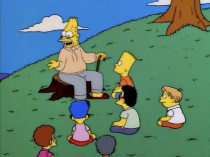An animated scene from The Simpsons shows Grandpa Simpson sitting on a tree stump telling stories to Bart and other children gathered on the grass.