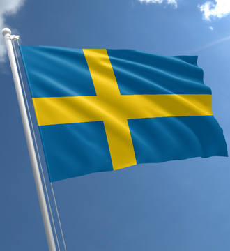 The Swedish flag waves against a blue sky, symbolizing Sweden's role as home to B Treasury Capital AB, Europe's first Bitcoin dividend firm. The flag's prominent display underscores the country's status as a leading hub of financial innovation on a per capita basis.