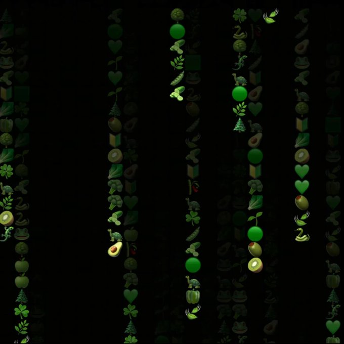 Vertical stripes of green-themed emojis—including avocados, limes, trees, clovers, and hearts—cascade down a black background, visually reinforcing the "money/green" motif of The New Money App's World Emoji Day post celebrating financial freedom.
