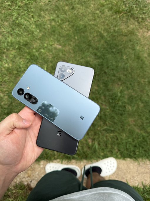 A hand holds two Solana Saga phones over a grassy background, with the caption highlighting the flex of owning two of these crypto-branded devices, matching the post's boast about the "biggest flex."